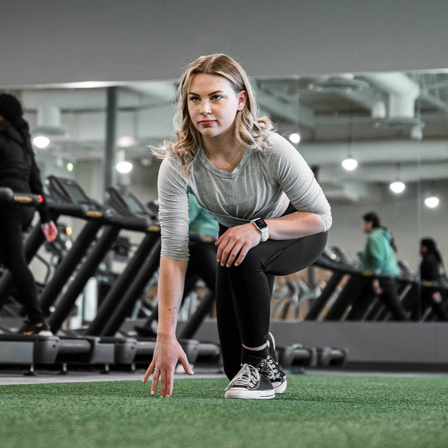 Woman in running position at the gym in Calgary