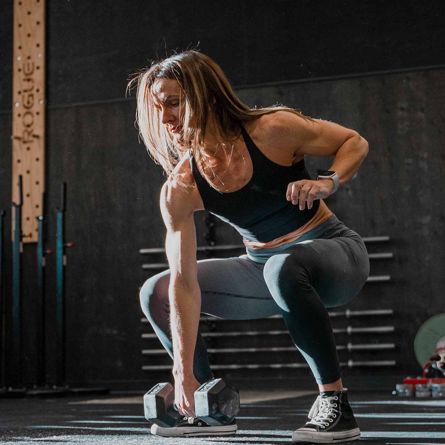 Muscular woman lifting a dumbbell in Calgary
